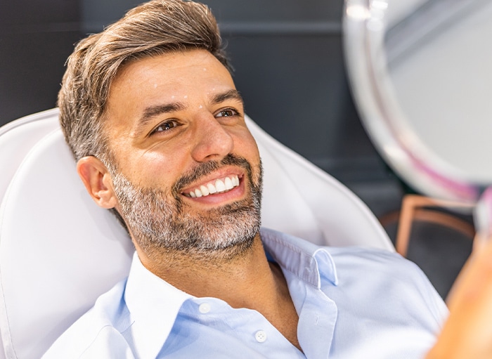 Man admiring his white teeth in a mirror