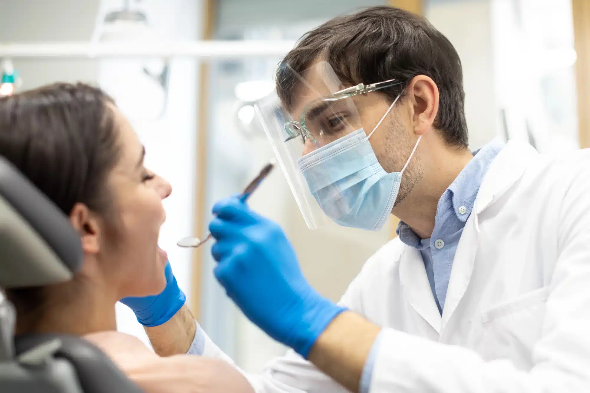 Dentist checking a patient before tooth extractions in Riverview, MI